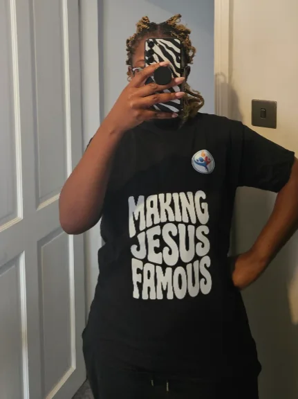 The reviewer wearing a black T-shirt printed with Making Jesus Famous